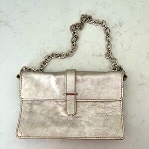 FURLA leather clutch with shoulder strap in metallic color.